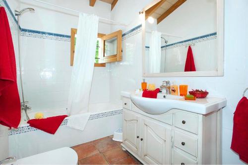 a white bathroom with a sink and a shower at Villa Burgues in Alcudia