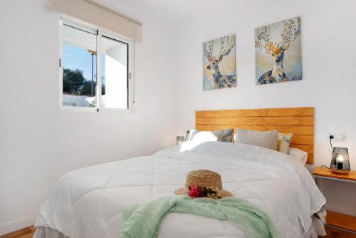 a bedroom with a white bed with a teddy bear on it at Zahora Qg in Barbate