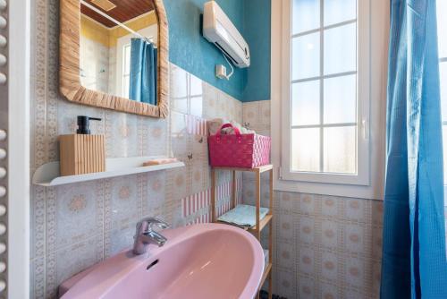 a bathroom with a pink sink and a mirror at Montée du Boiloa - Bielle, Laruns in Bielle