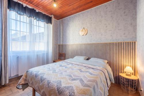a bedroom with a bed and a large window at Montée du Boiloa - Bielle, Laruns in Bielle