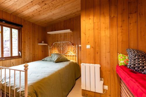 a bedroom with a bed and a red couch at La Cabane d'Ana in Bordeaux