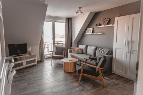 a living room with a couch and a tv at Lagunenstadt am Haff - Fewo 157 Haffblick in Ueckermünde