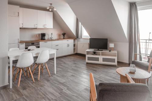 a kitchen and a living room with a table and chairs at Lagunenstadt am Haff - Fewo 157 Haffblick in Ueckermünde