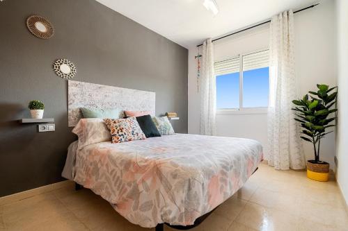 a bedroom with a bed and a large window at Montserrat in Miami Platja