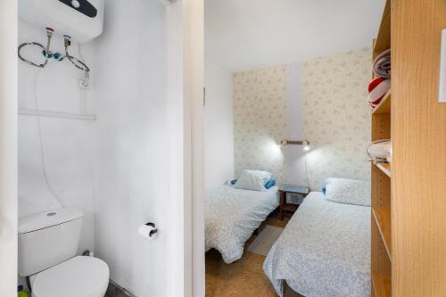 a small bedroom with two beds and a toilet at La Estrella in Hermigua