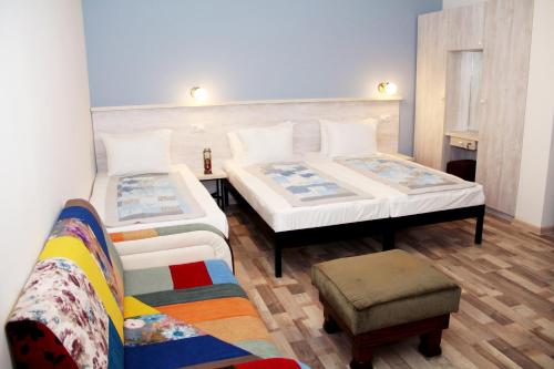 Habitación con 2 camas y una silla. en Hotel Delisi en Tiflis