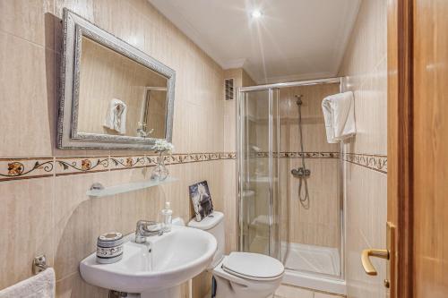 a bathroom with a toilet and a sink and a shower at Mariners in Alcudia