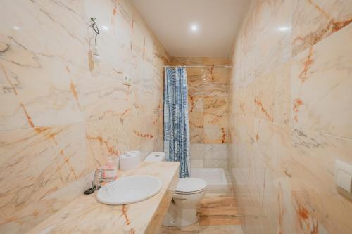 a bathroom with a sink and a toilet and a tub at Los Mirlos in Navaluenga
