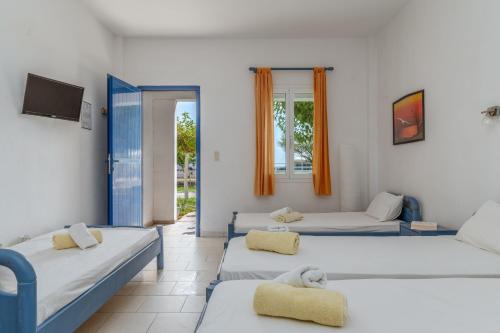 a room with three beds and a tv at Perasma Studios 7 in Kipri