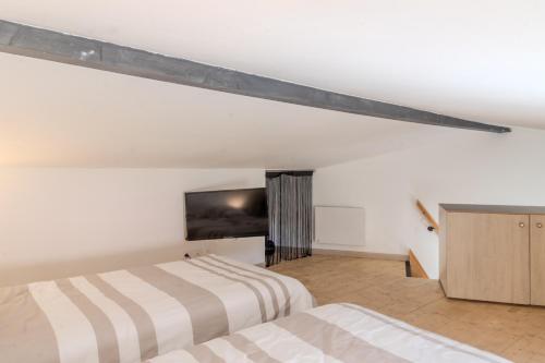 two beds in a room with white walls at Gite Berclois in Bercloux