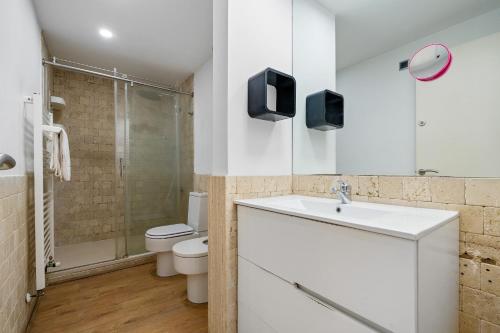 a bathroom with a sink and a toilet and a shower at Voramar in Torredembarra
