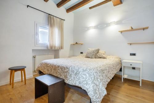 a white bedroom with a bed and a window at Voramar in Torredembarra