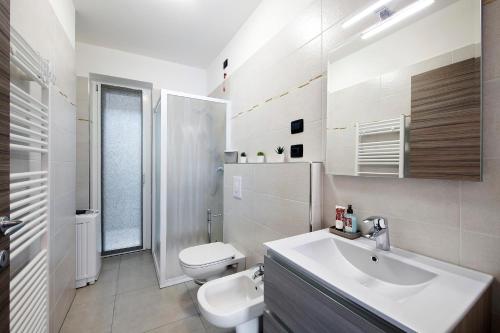 a white bathroom with a sink and a toilet at Appartamento 2 in Nesso