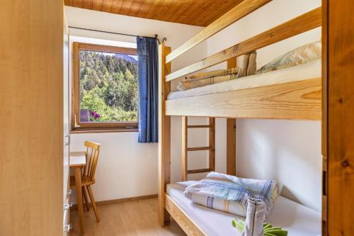 a bedroom with two bunk beds and a table at Pardellerhof Tschafonblick in Campodazzo