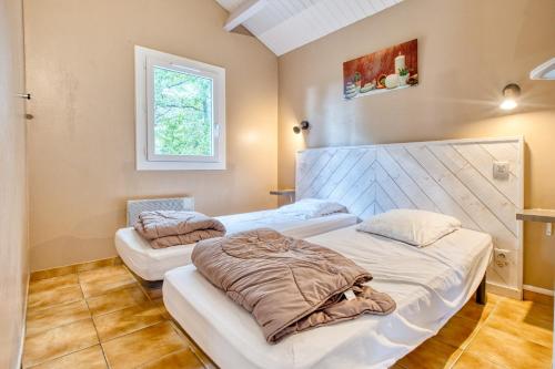 a room with two beds and a window at Gite Gariotte in Salignac Eyvigues
