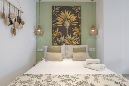 a bed in a room with a painting on the wall at Apartamento Black Palm 1 9 in Tarifa