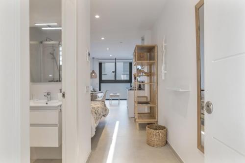 a white bathroom with a sink and a mirror at Apartamento Black Palm 1 9 in Tarifa