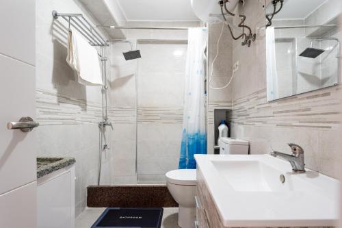 a bathroom with a toilet and a sink and a shower at Casa de Bella Fuengirola in Fuengirola