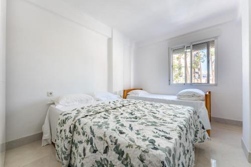 a bedroom with two beds and a window at Casa de Bella Fuengirola in Fuengirola