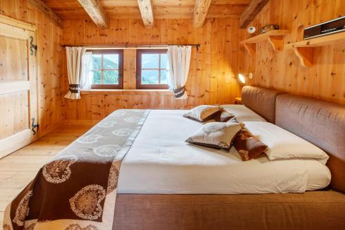 a bedroom with a large bed in a wooden room at Chalet Del Cuore in Valdisotto