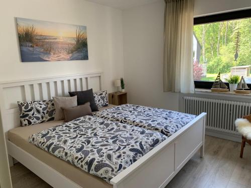 a bedroom with a bed with a blue and white comforter at Ferienwohnung Halvar in Maasholm
