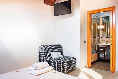a living room with a chair and a television at La Chirumba in Aldeatejada