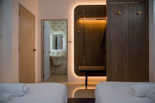 a room with two beds and a bathroom with a sink at Terra Sky Home in Pak Chong
