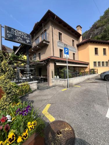a parking lot in front of a building with flowers at Boato Bistrot & Bed in Tegna
