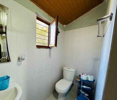 a bathroom with a toilet and a sink and a window at Siera Home in Berat