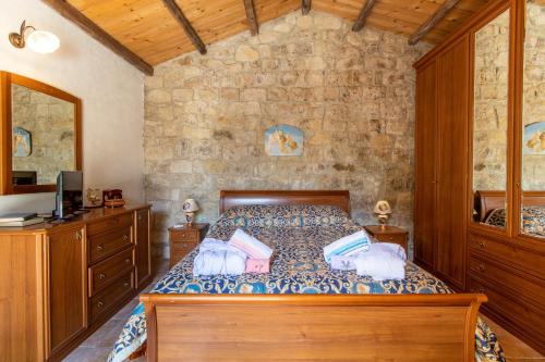 a bedroom with a bed and a stone wall at Casa Il Carrubbo in Modica