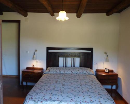 a bedroom with a large bed and two night stands at Los Cascos in Fuenteheridos