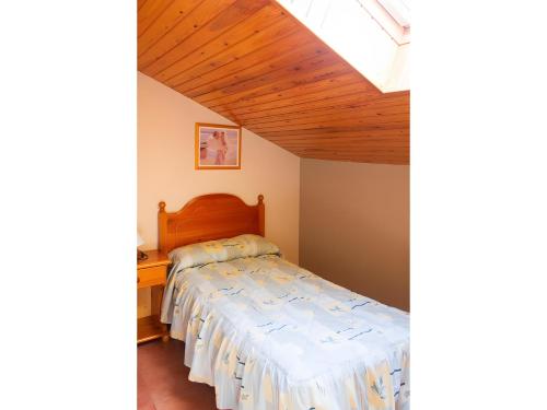 a bedroom with two beds and a wooden ceiling at Peña Yerga in Hospital