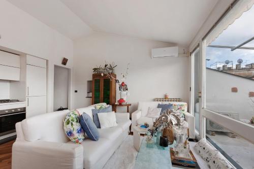 ein Wohnzimmer mit weißen Möbeln und einem großen Fenster in der Unterkunft Chiavari Elegante in Chiavari