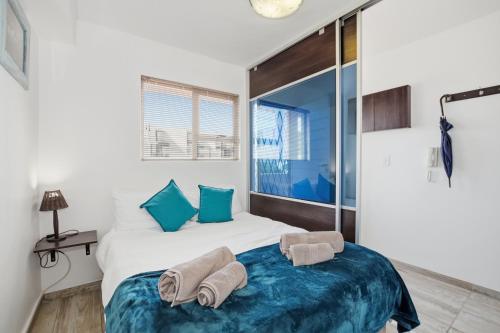 a bedroom with a bed with towels on it at Nautica by the Sea in Cape Town