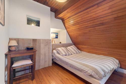 a bedroom with a bed and a wooden wall at Gîte de La Séoube in Campan