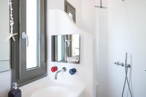 a bathroom with a sink and a mirror at Luna Rossa Milos - Chili Moon in Provatas