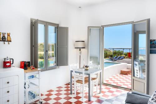 a living room with a table and a view of the ocean at Luna Rossa Milos - Chili Moon in Provatas