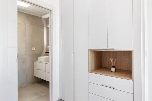 a bathroom with white cabinets and a sink at Chalet con Piscina en San Javier in San Javier