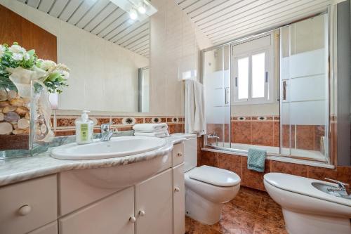 a bathroom with a sink and a toilet and a mirror at Atico Duplex Pepe y Rosi in Cunit