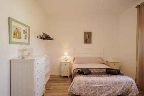a bedroom with a bed and a white dresser at Villa Manolita in Carmona