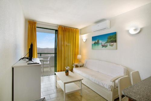a living room with a couch and a tv in it at Casa Puerto Rico in Mogán