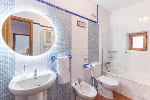 a bathroom with a sink and a toilet and a mirror at De los Maestros in El Arenal