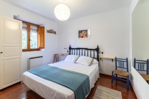 a bedroom with a large bed and a chair at De los Maestros in El Arenal