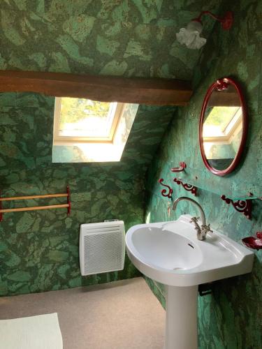 ein Badezimmer mit Waschbecken und Spiegel in der Unterkunft La Béchetière in Parcé-sur-Sarthe