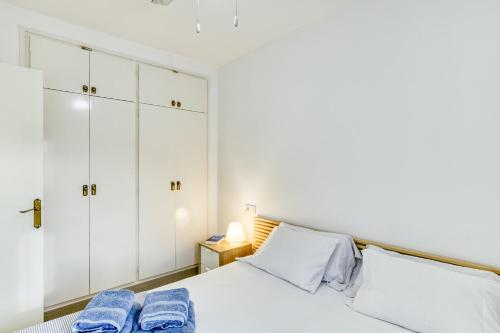 a bedroom with a white bed and white cabinets at Lago Sant Mauricio in Empuriabrava