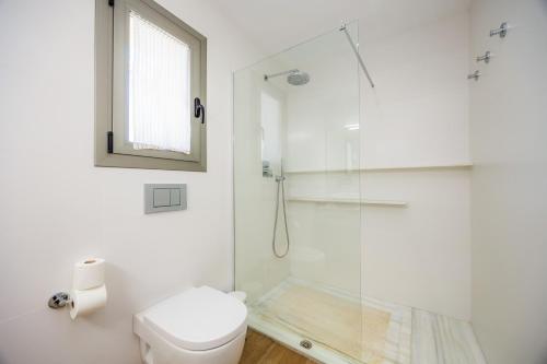a white bathroom with a shower and a toilet at Finca Son Montserrat in Llucmajor