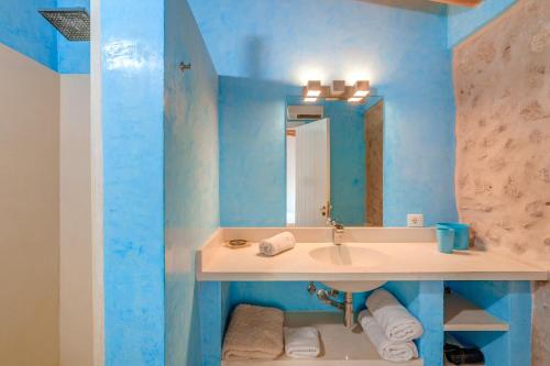 a blue bathroom with a sink and a mirror at Possessio Sa Barrala Gallinero in Campos