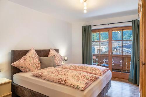 a bedroom with a bed and a large window at Fewo Maria Grasegger in Grainau