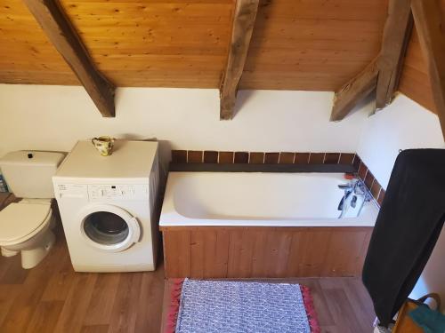 a small bathroom with a washing machine and a toilet at Maison de Vacances Chadirac in Auriac