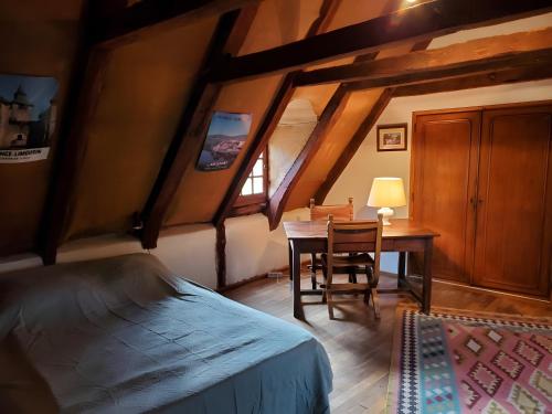 a bedroom with a bed and a desk and a table at Maison de Vacances Chadirac in Auriac